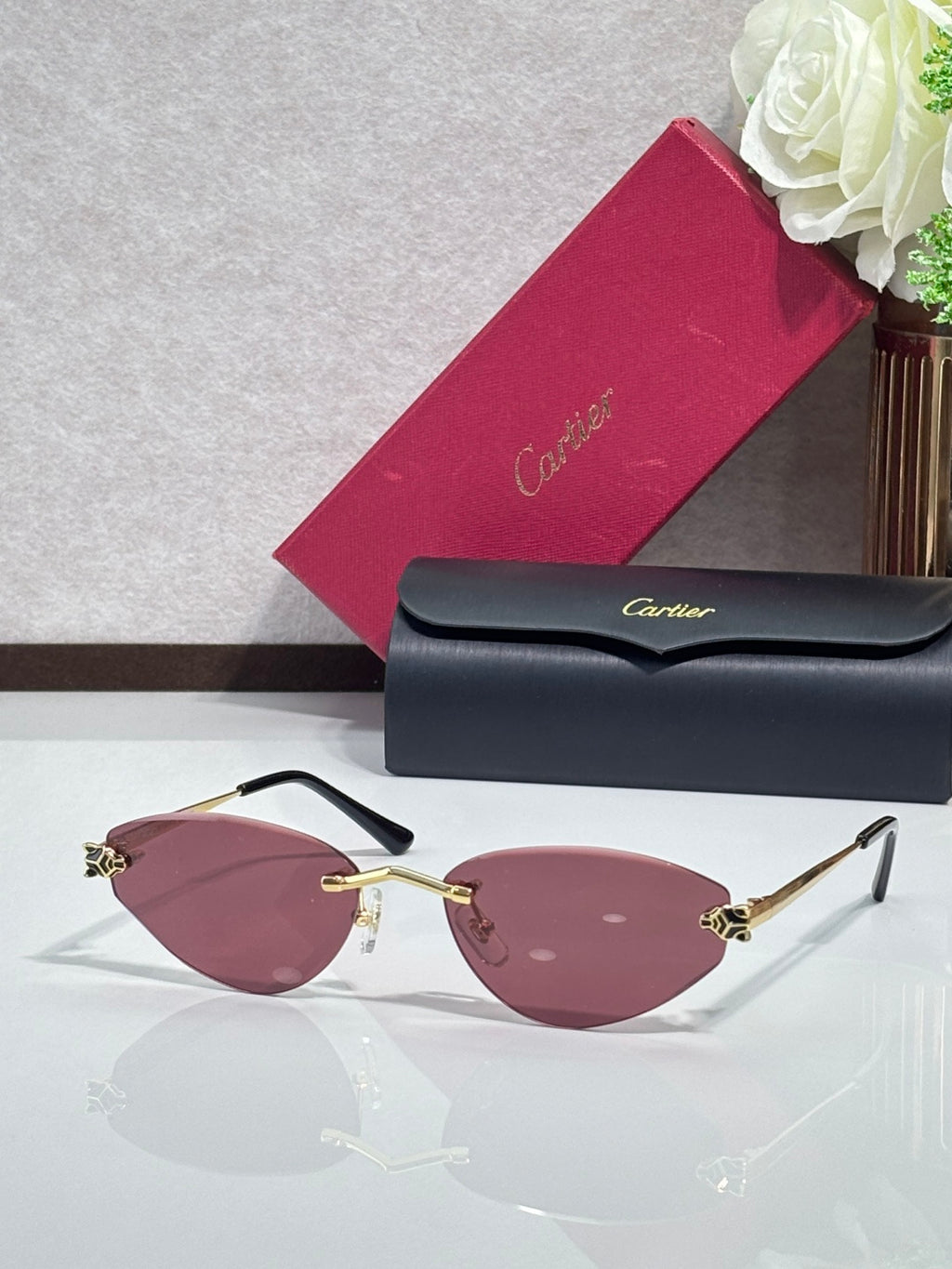 Gold-rim sunglasses with wine pink lenses and black temple tips