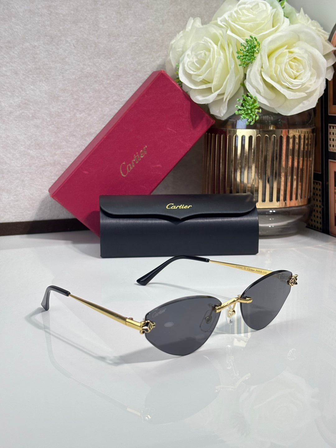 Gold-rim sunglasses with dark gray lenses and black temple tips