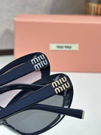 MiuMiu cat-eye sunglasses close-up with dark frame arms and embossed logo detail