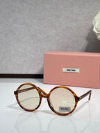 MiuMiu sunglasses with tortoiseshell round frames and clear lenses, logo on lens