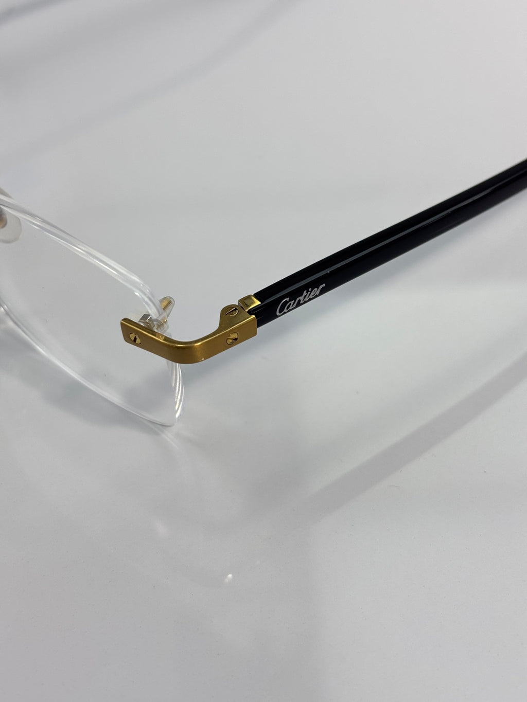 Cartier eyeglasses close-up of gold bridge and black frame temple
