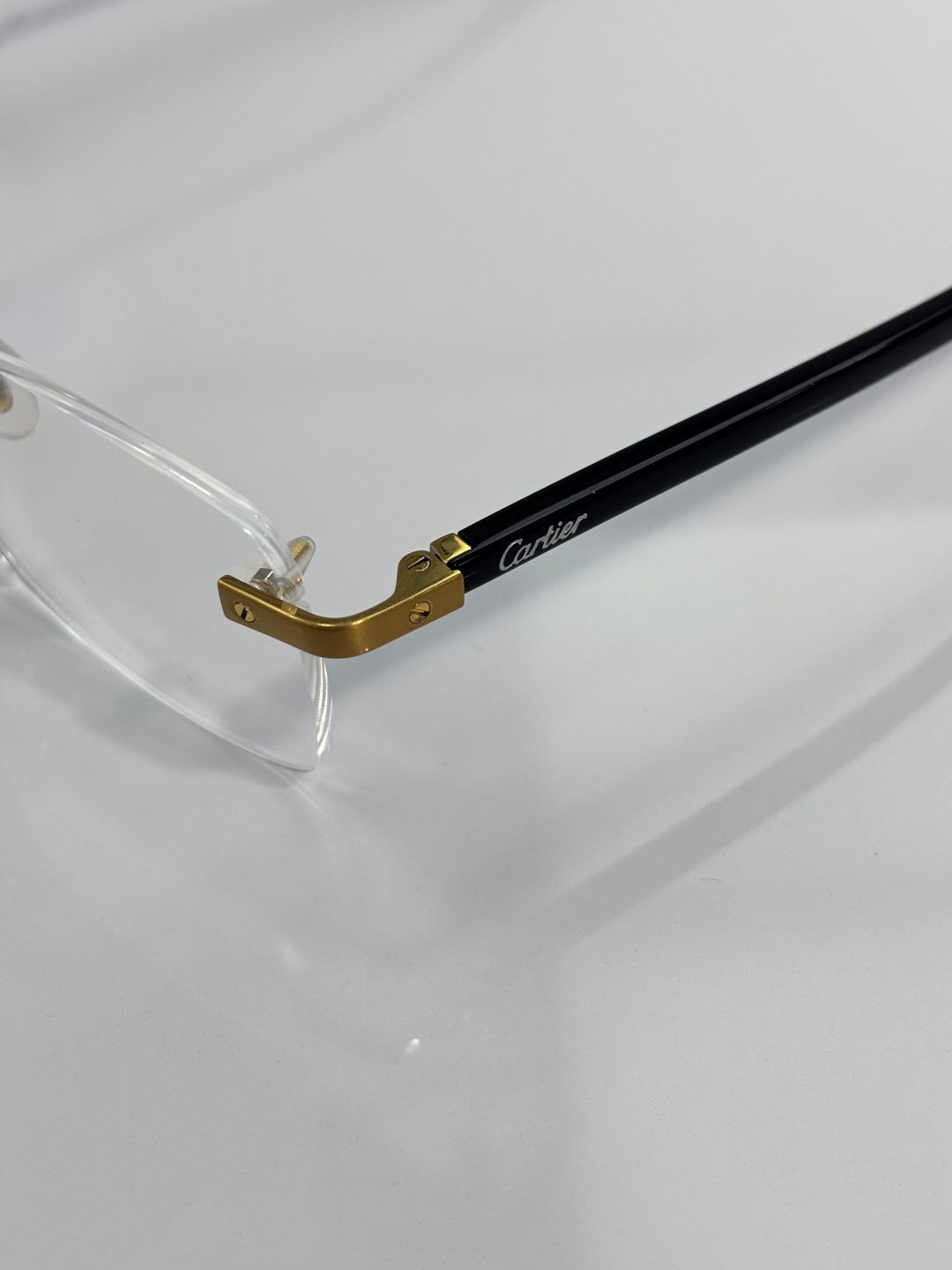 Cartier eyeglasses close-up of gold bridge and black frame temple