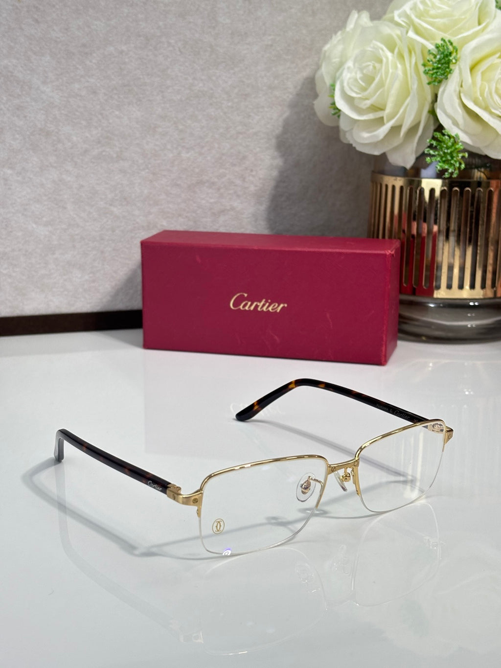 Cartier eyeglasses with gold frame and clear lenses, black temples, arched bridge