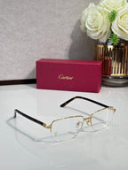 Cartier eyeglasses with gold frame and clear lenses, black temples, arched bridge