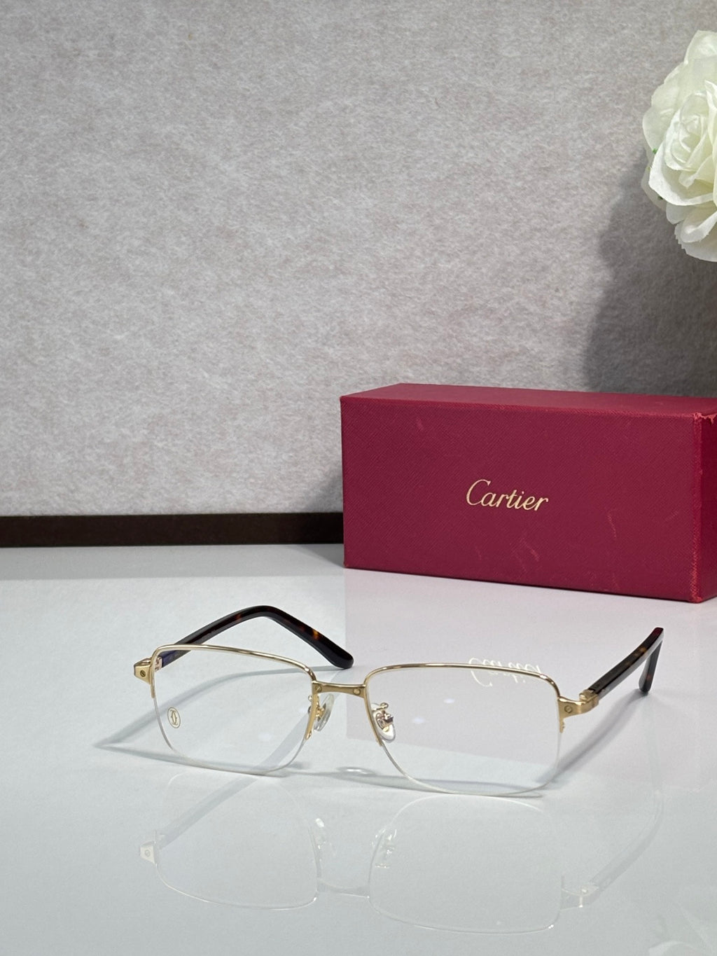 Cartier eyeglasses with gold frame and clear lenses, black temple tips