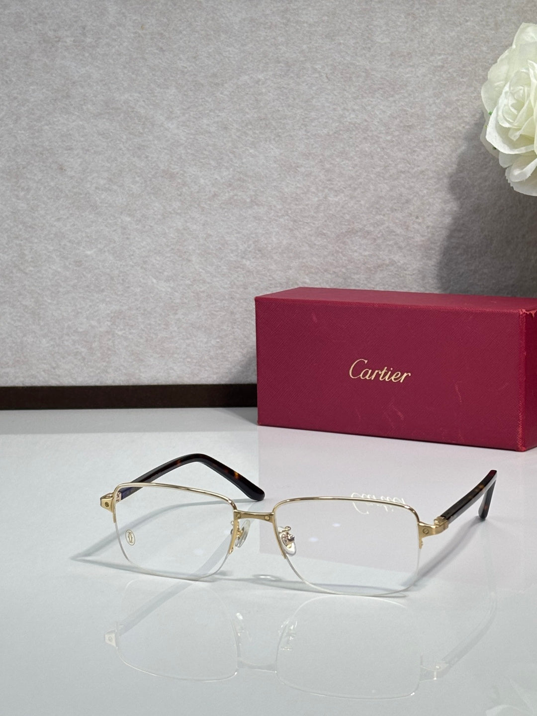 Cartier eyeglasses with gold frame and clear lenses, black temple tips