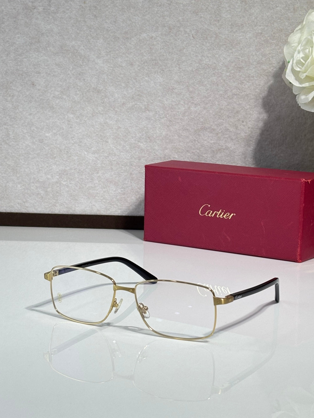 Gold rectangular eyeglasses with black temple arms and clear lenses