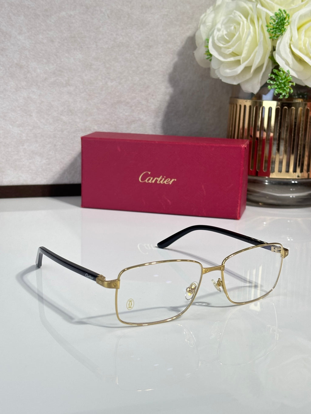 Gold rectangular eyeglasses with black temple tips and clear lenses