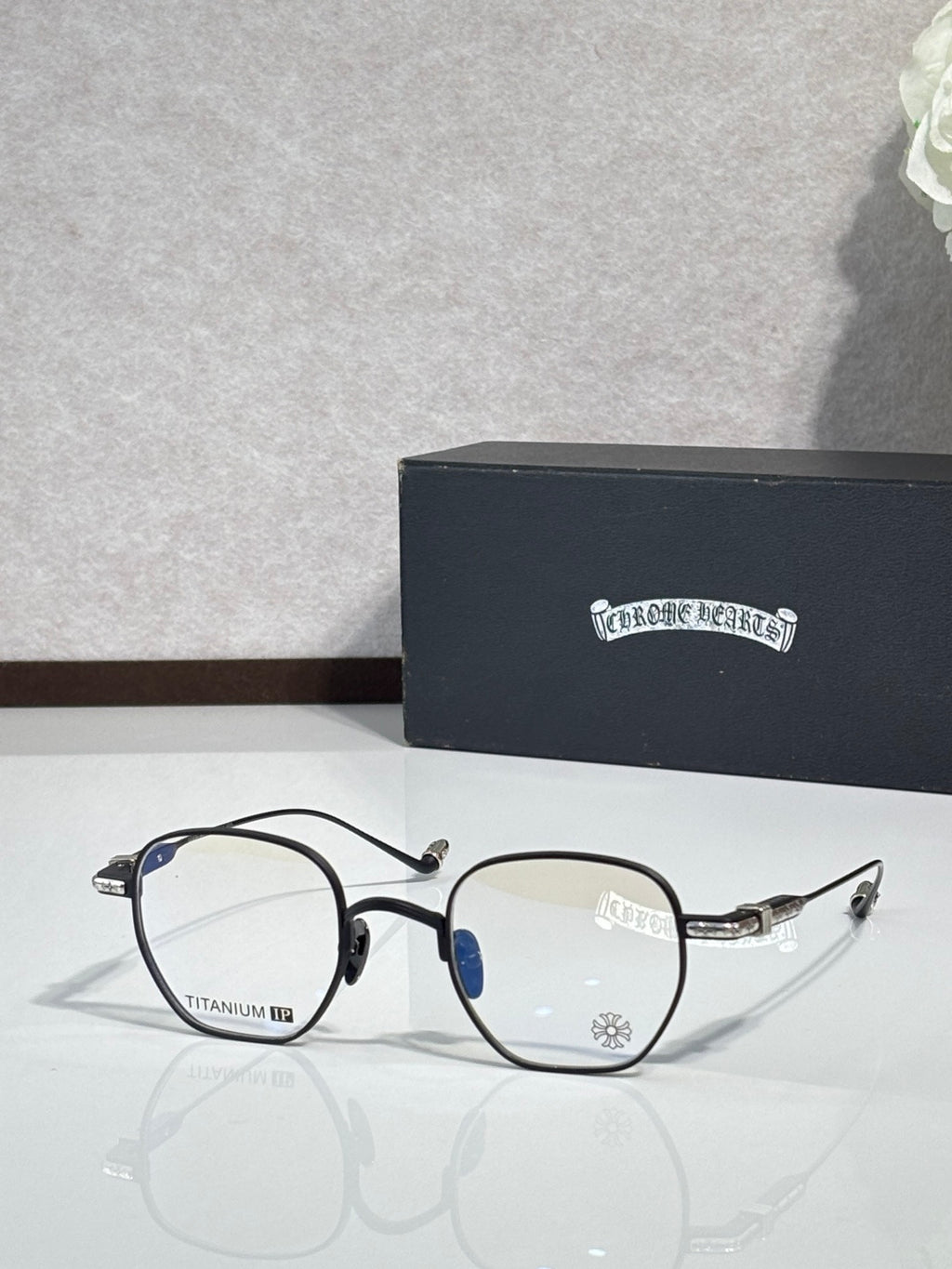 Black and gold round eyeglasses with clear lenses and blue accent on arms.