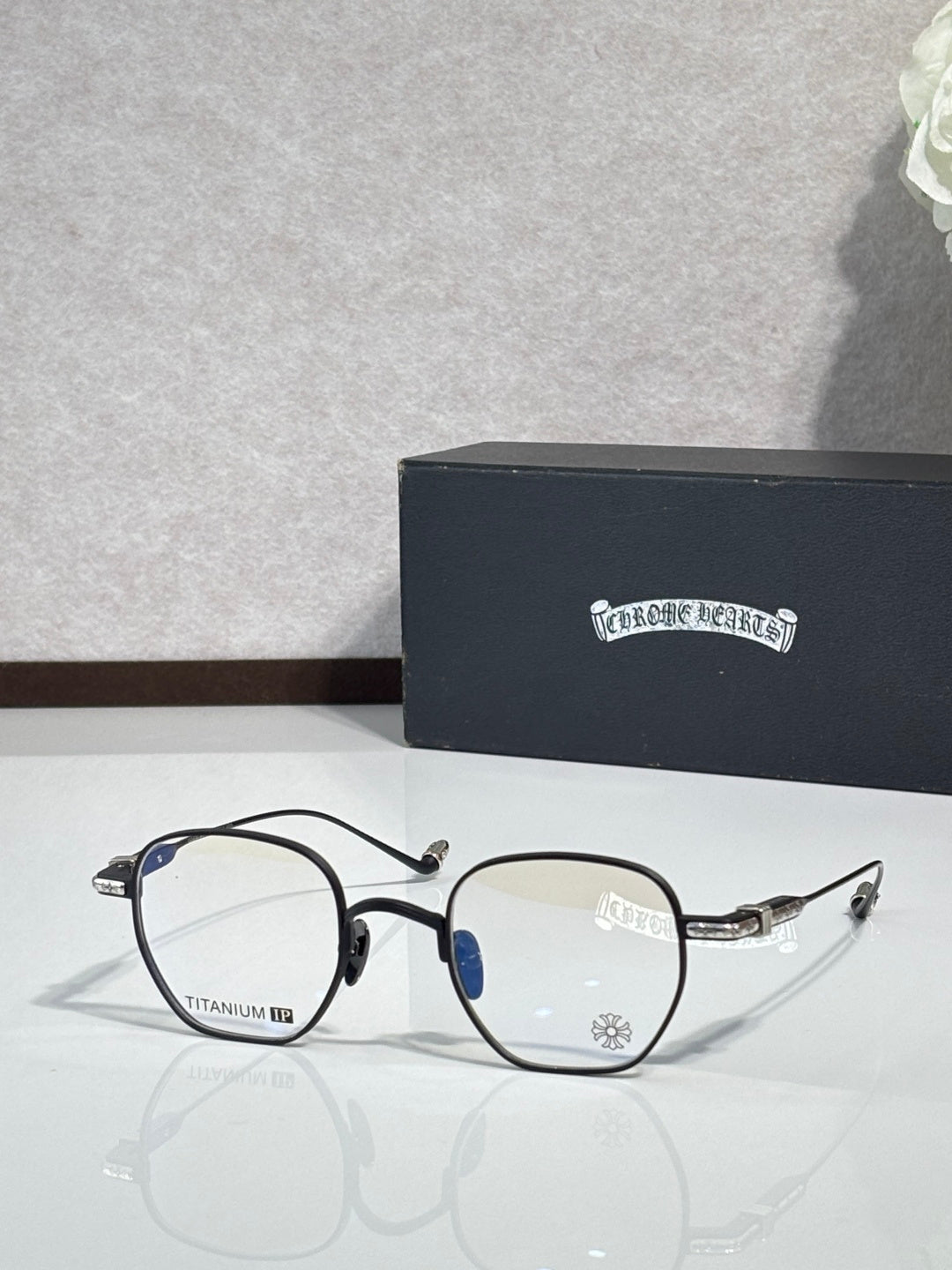 Black and gold round eyeglasses with clear lenses and blue accent on arms.