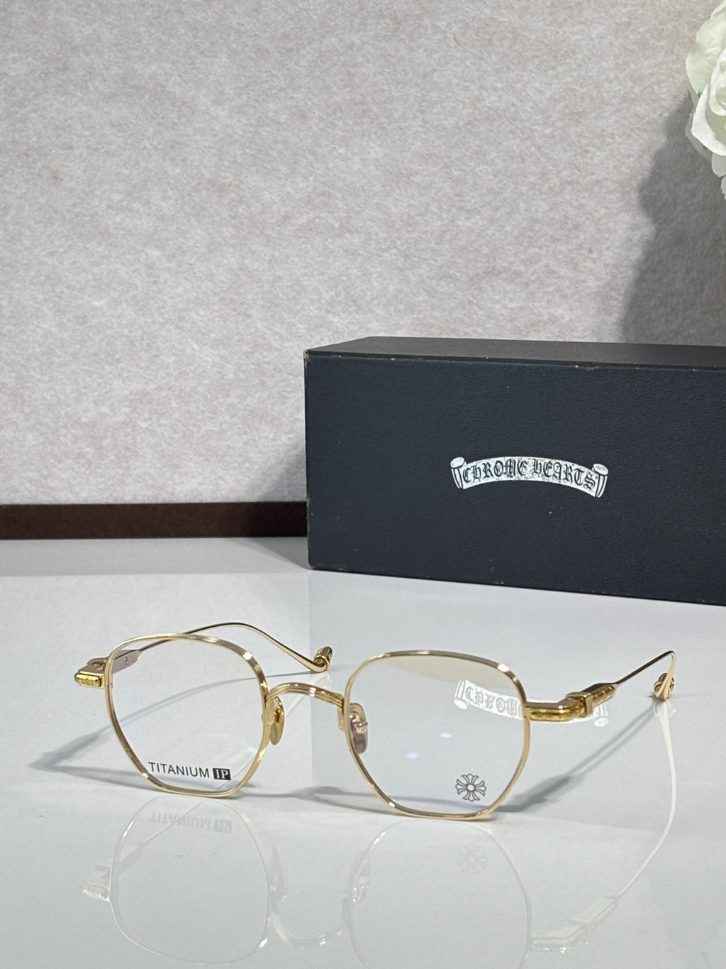 Gold round eyeglasses with clear lenses and decorative metal temple details.
