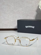 Gold round eyeglasses with clear lenses and decorative metal temple details.