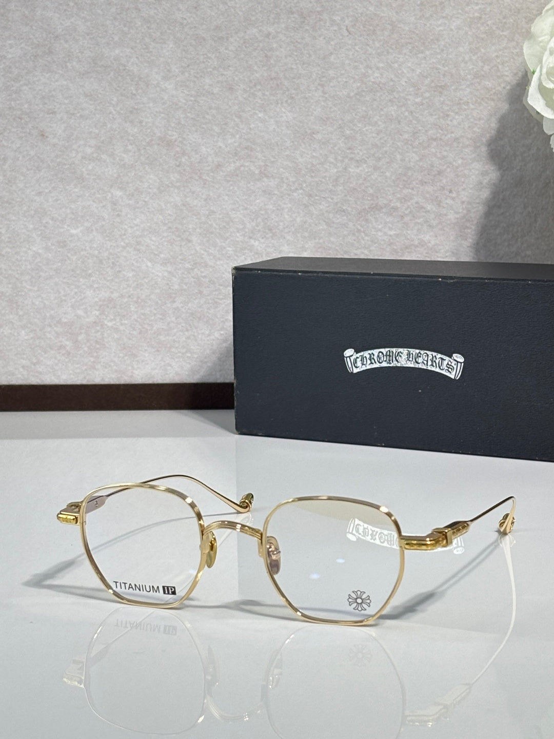 Gold round eyeglasses with clear lenses and decorative metal temple details.
