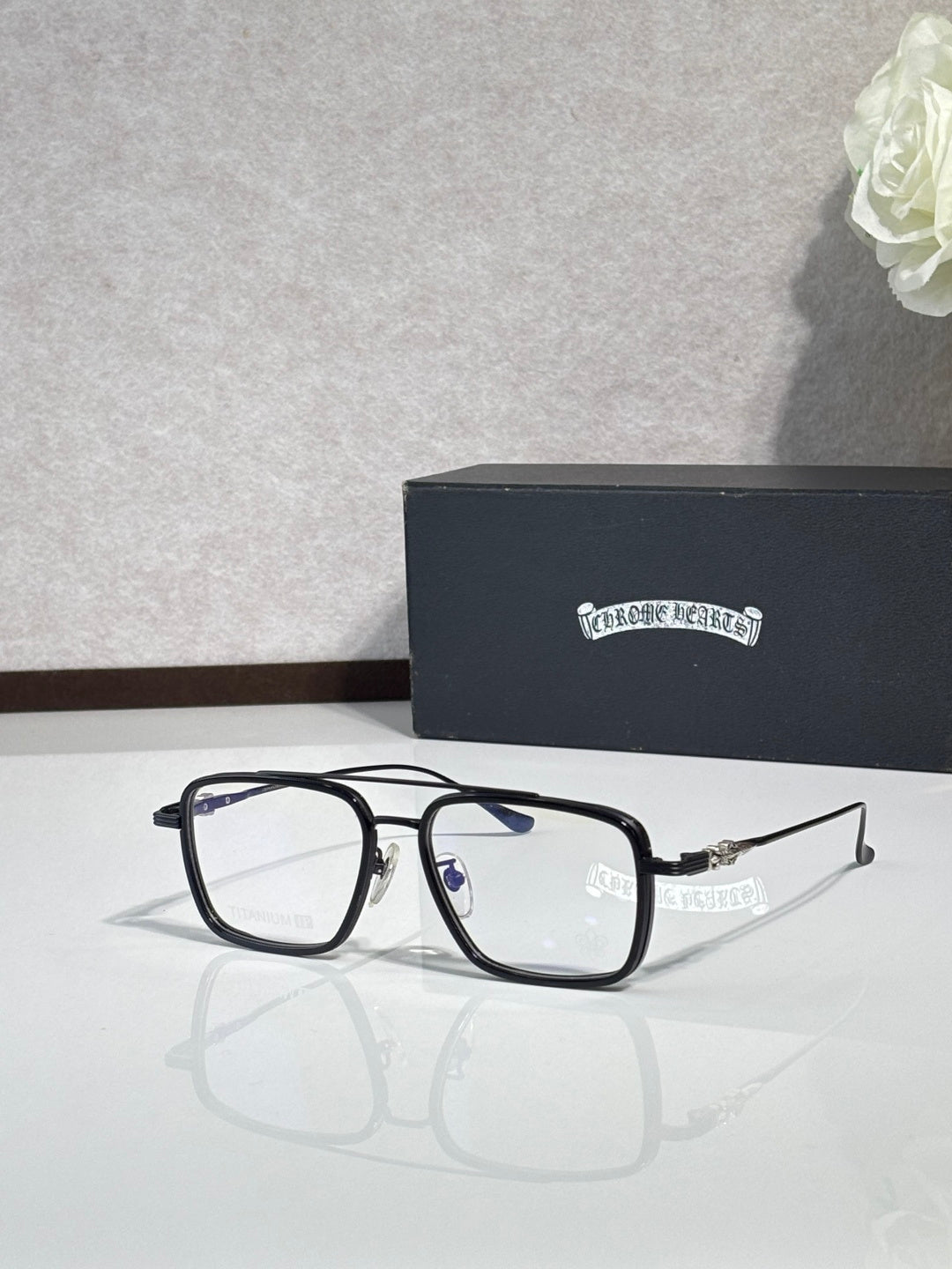 Black rectangular eyeglasses with clear lenses and blue accent on temples.