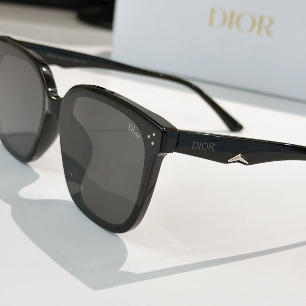 Black sunglasses with dark lenses, Dior logo on temple, and star-shaped metal detail