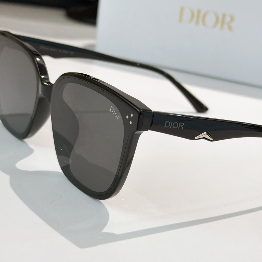 Black sunglasses with dark lenses, Dior logo on temple, and star-shaped metal detail