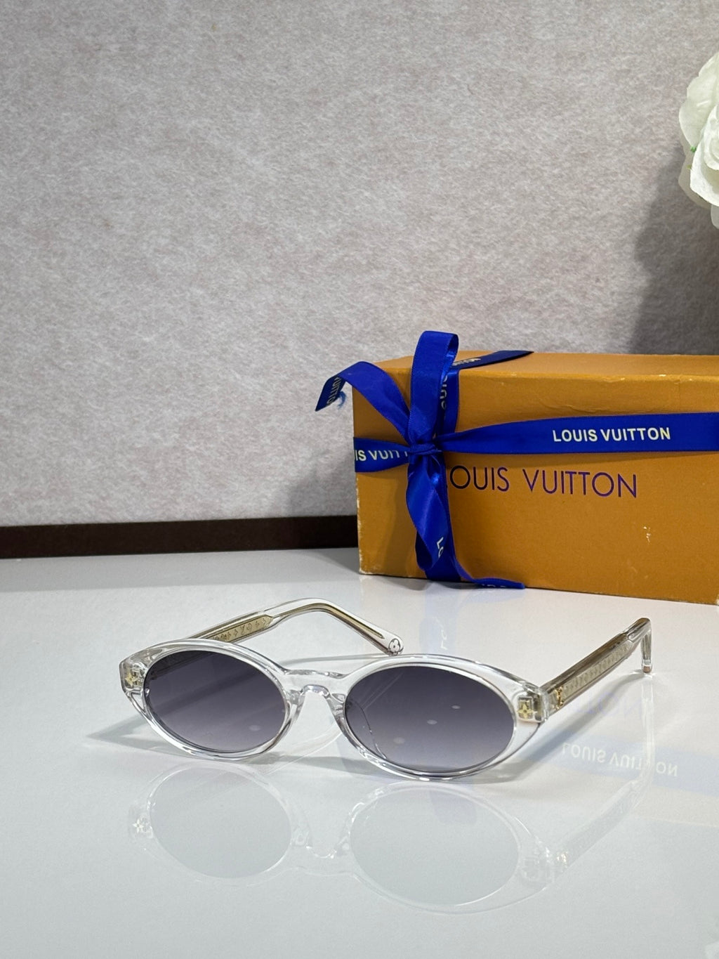 Louis Vuitton oval sunglasses with silver frame and dark lenses, metal-tipped arms