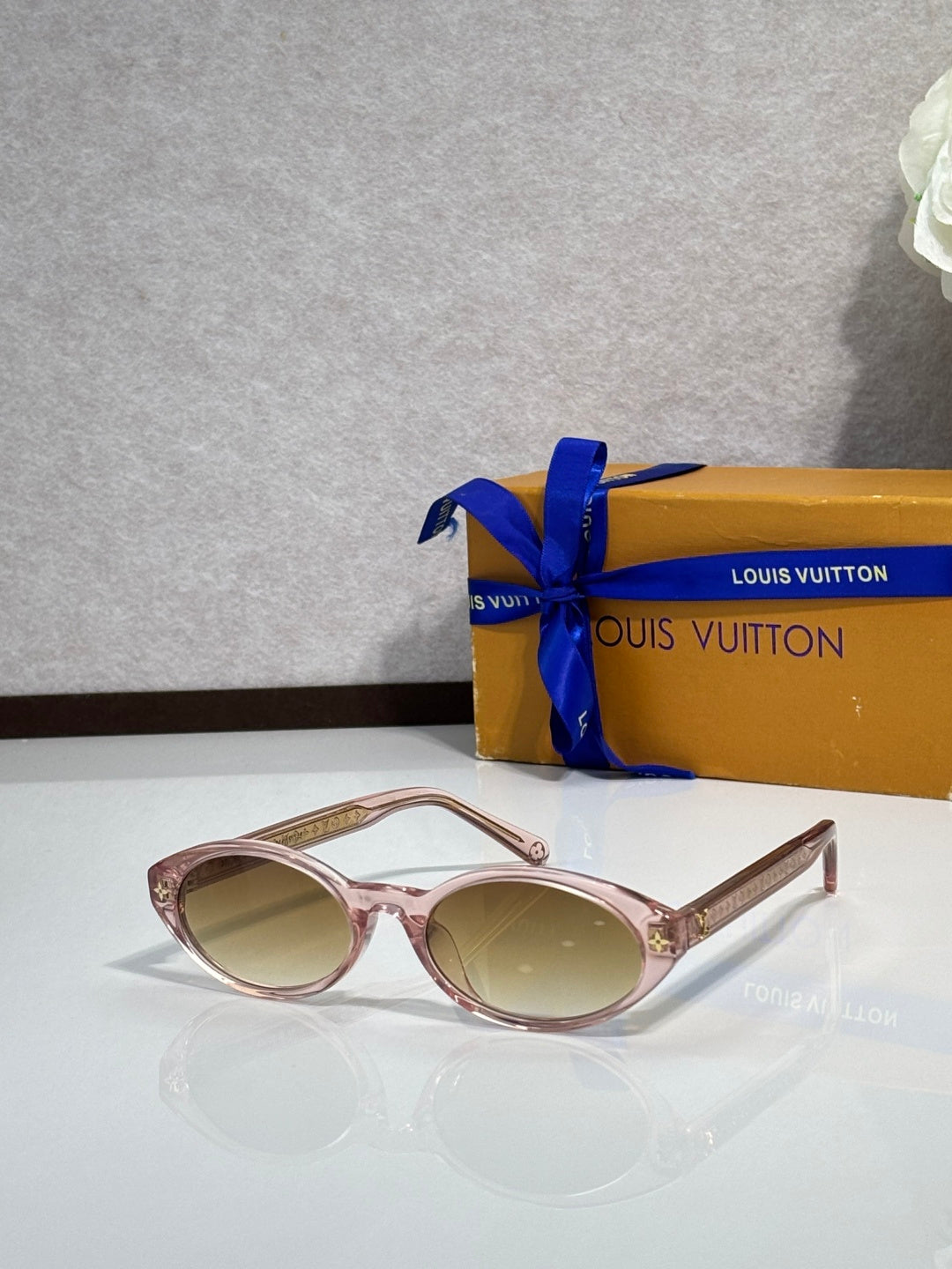 Louis Vuitton oval sunglasses with pink frame and light-tinted lenses, metal tips