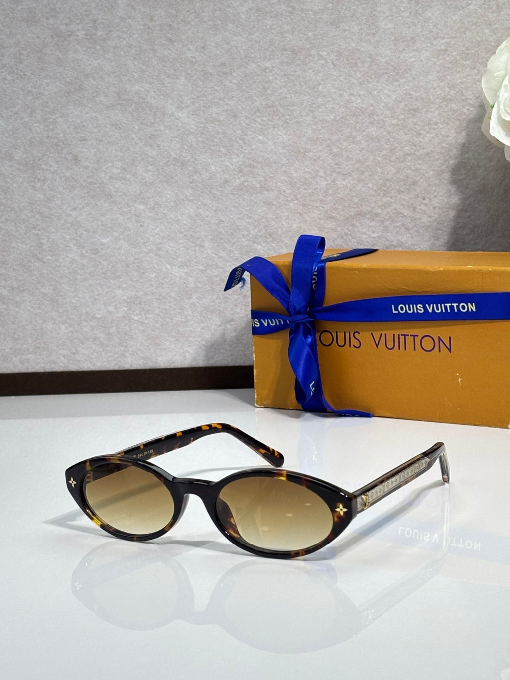 Louis Vuitton cat-eye sunglasses, black frame with amber-tinted lenses and star temples