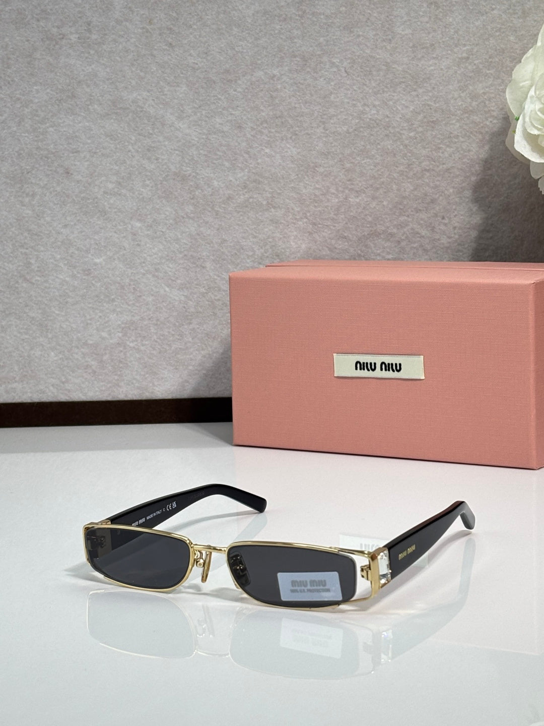 MiuMiu gold eyeglass frame with black temples and dark lenses
