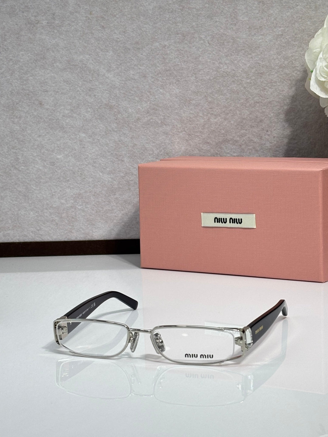 MiuMiu silver eyeglass frame with black temples and clear lenses