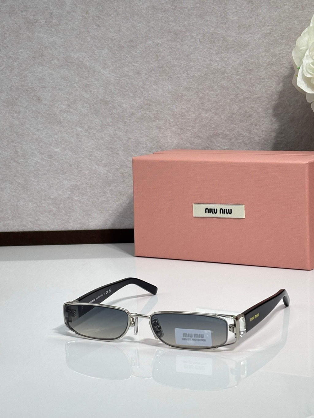 MiuMiu silver eyeglass frame with black temples and dark lenses