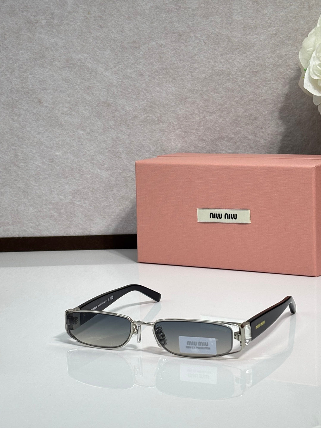 MiuMiu silver eyeglass frame with black temples and dark lenses