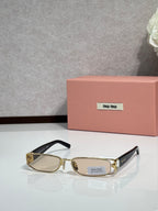 MiuMiu gold eyeglass frame with black temples and clear lenses
