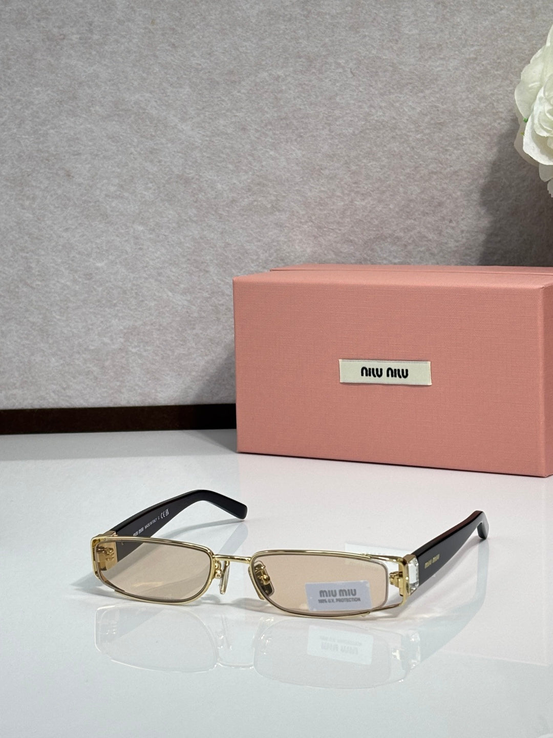 MiuMiu gold eyeglass frame with black temples and clear lenses