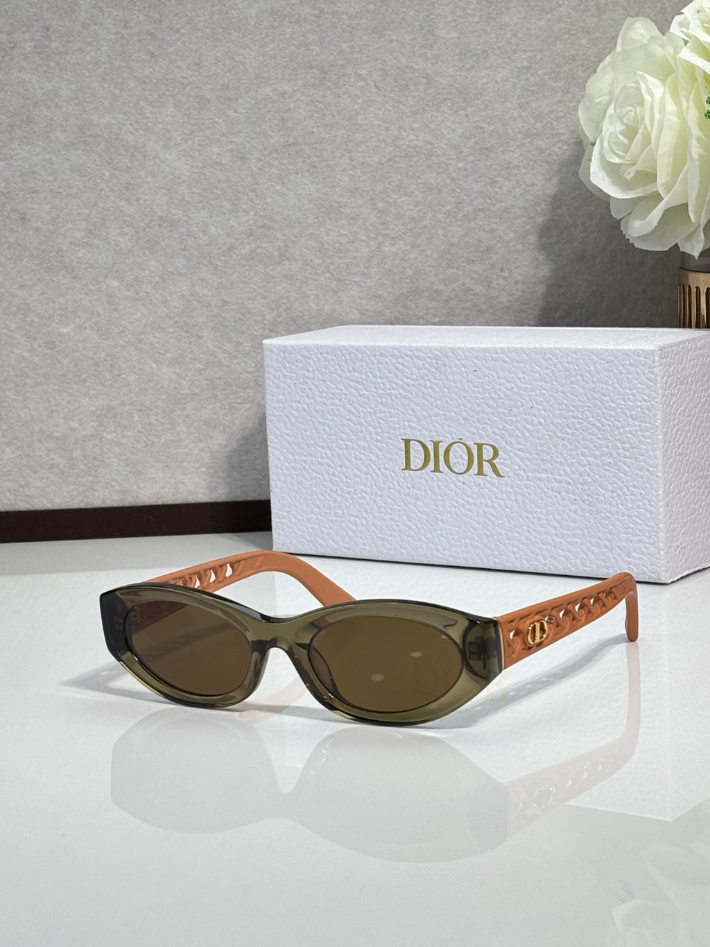 Dior sunglasses with tan-brown oval frames and dark lenses
