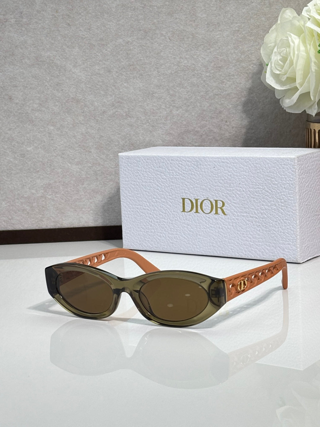 Dior sunglasses with tan-brown oval frames and dark lenses