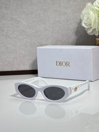 Dior sunglasses with white oval frames and dark tinted lenses