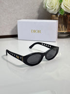 Dior sunglasses with black oval frames and dark lenses, gold accents