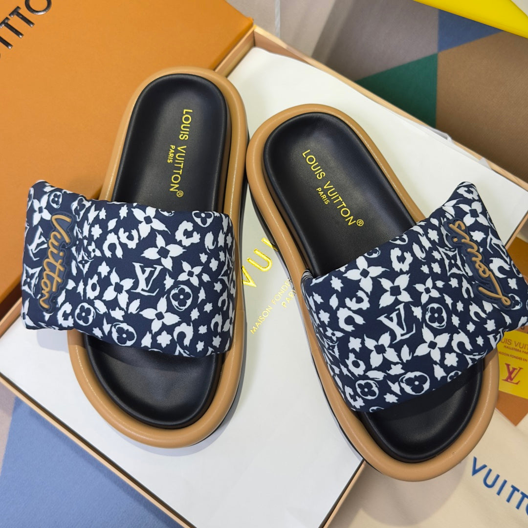Louis Vuitton slide sandals with navy-and-white monogram straps and black footbeds, tan soles