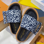 Louis Vuitton slide sandals with navy-and-white patterned straps over black footbeds and tan edges