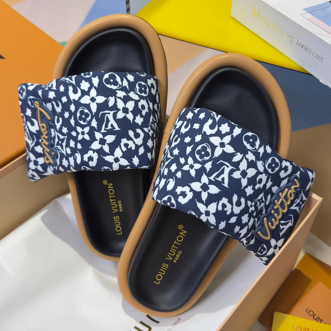 Louis Vuitton slide sandals with navy-and-white patterned straps over black footbeds and tan edges