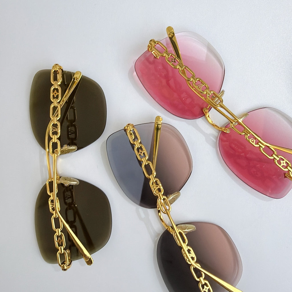 Louis Vuitton sunglasses with gold chain straps and tinted lenses, laid out