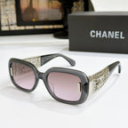 Chanel glasses with charcoal frame, gold patterned temples, and purple-tinted lenses