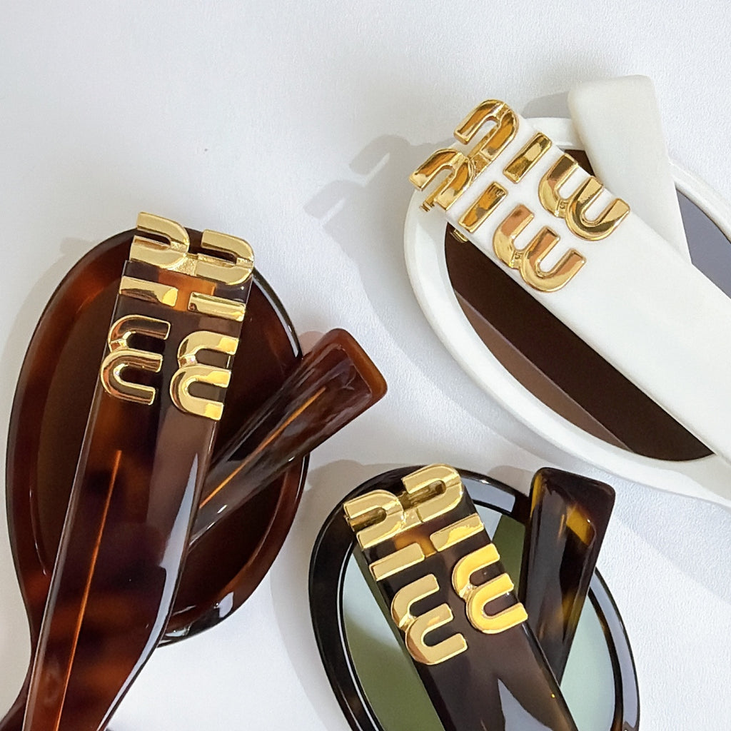 Sunglasses with gold logo temples and large oval frames in dark brown and white