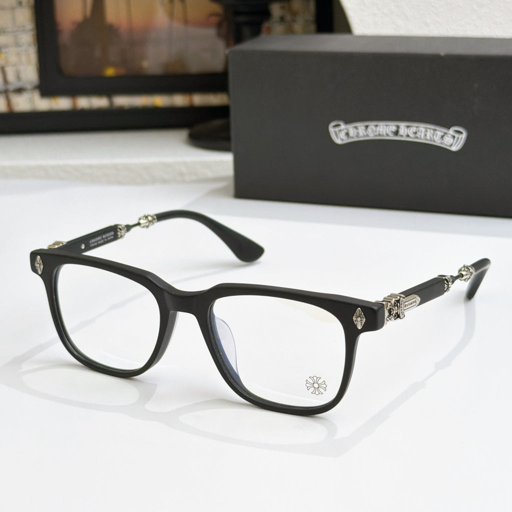 Black eyeglass frames with clear lenses, gold embellishments on temples and bridge
