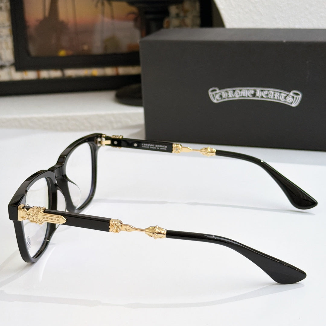 Black eyeglass frames in side view with clear lenses and gold decorative temples