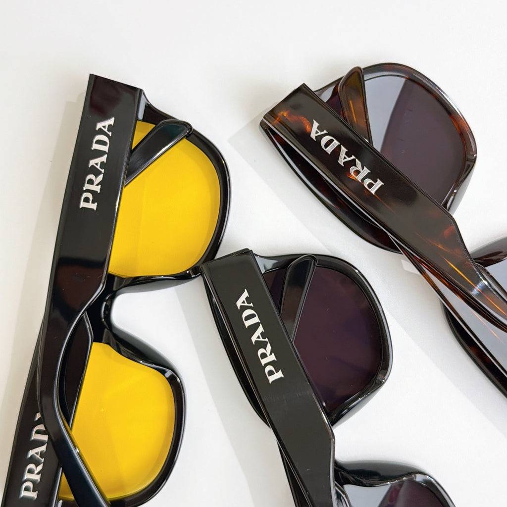 Assorted PRADA sunglasses with yellow and purple lenses in dark frames