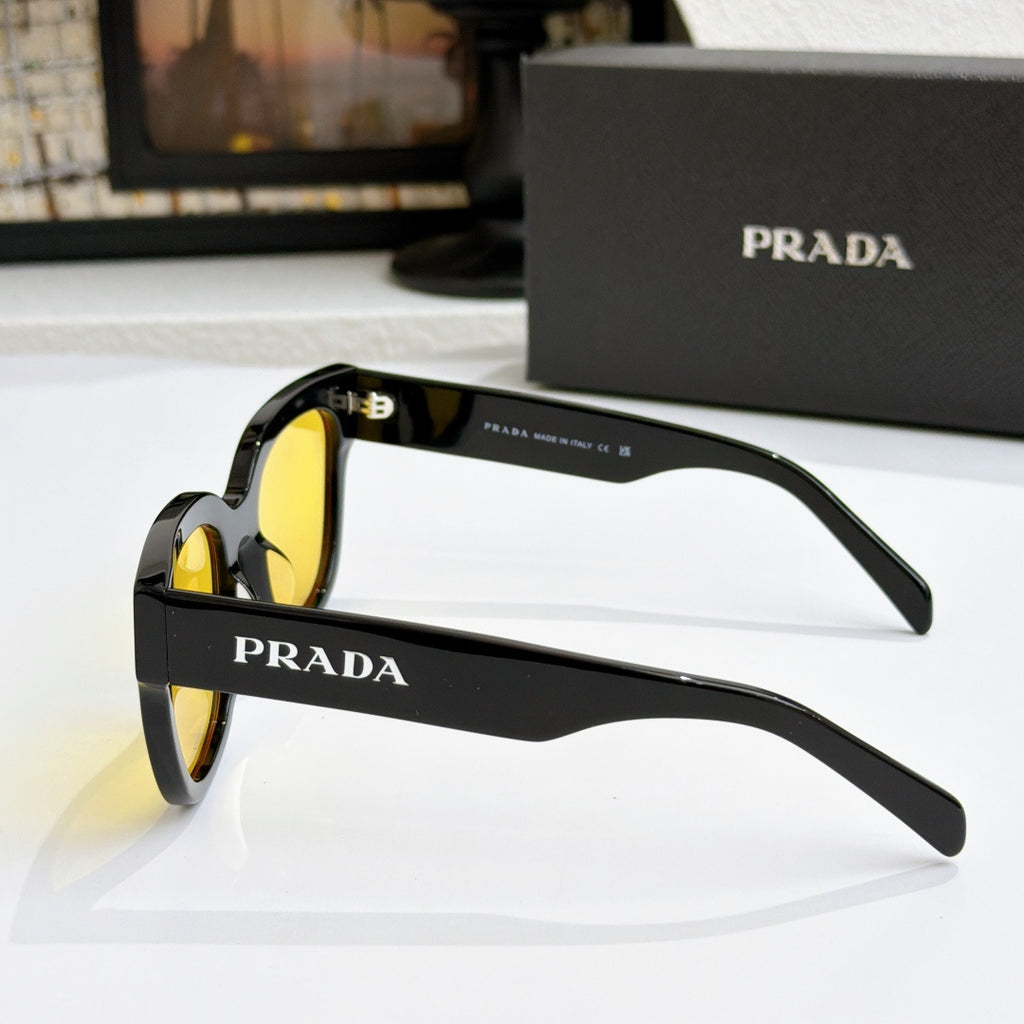 Black sunglasses side view with yellow lenses and PRADA branding on arm