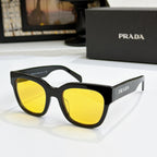 Black sunglasses with yellow gradient lenses and PRADA logo on temples