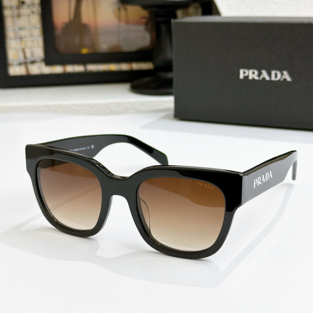 Dark sunglasses with tan gradient lenses and PRADA logo on temples