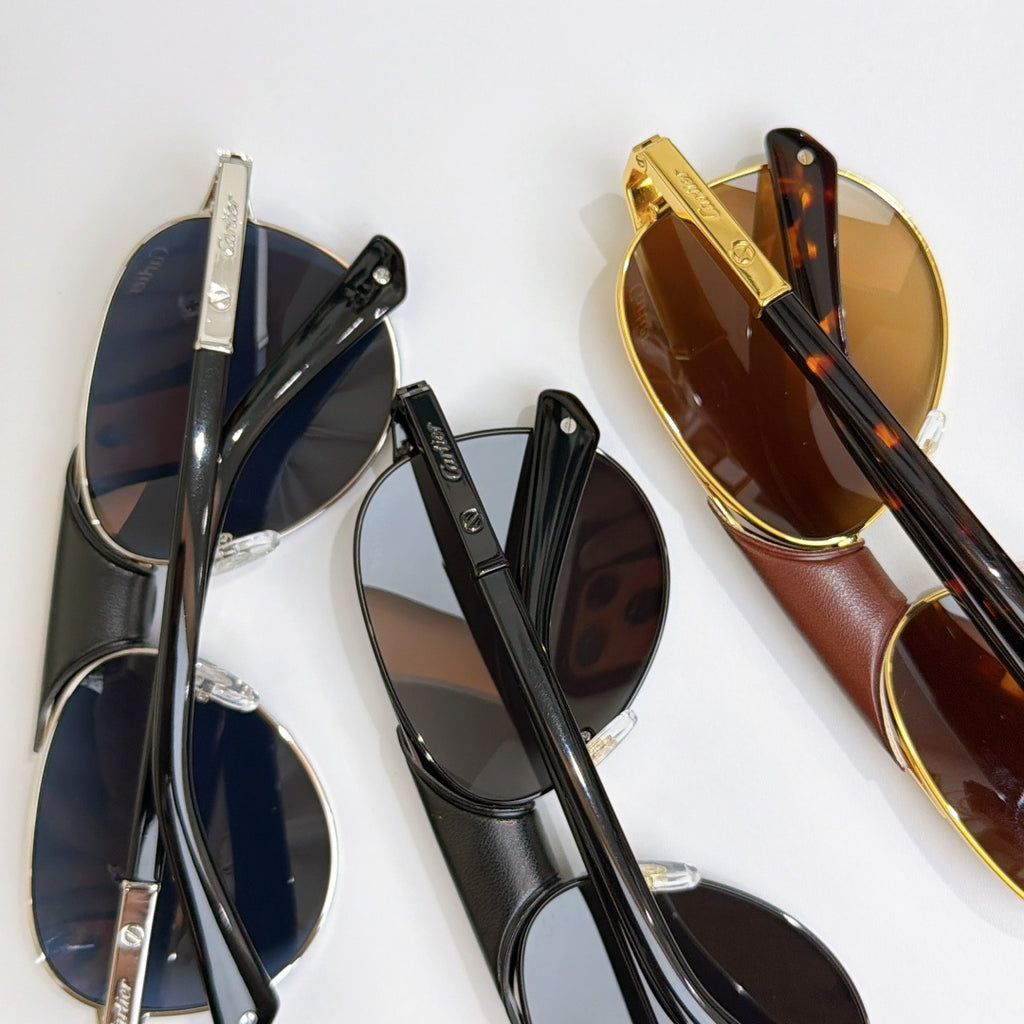 Cartier sunglasses set: black pair and gold pair with tinted lenses (side view)