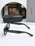 Balenciaga black sunglasses with clear-toned side arms and dark lenses