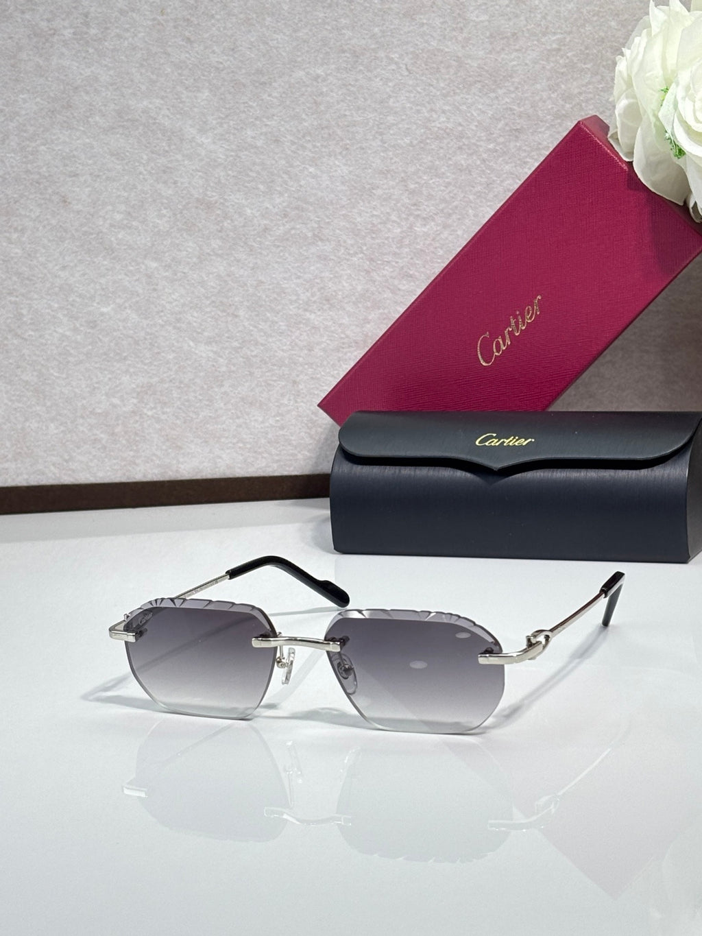 Cartier sunglasses with smoky gray lenses and black frame, gold hinge accents