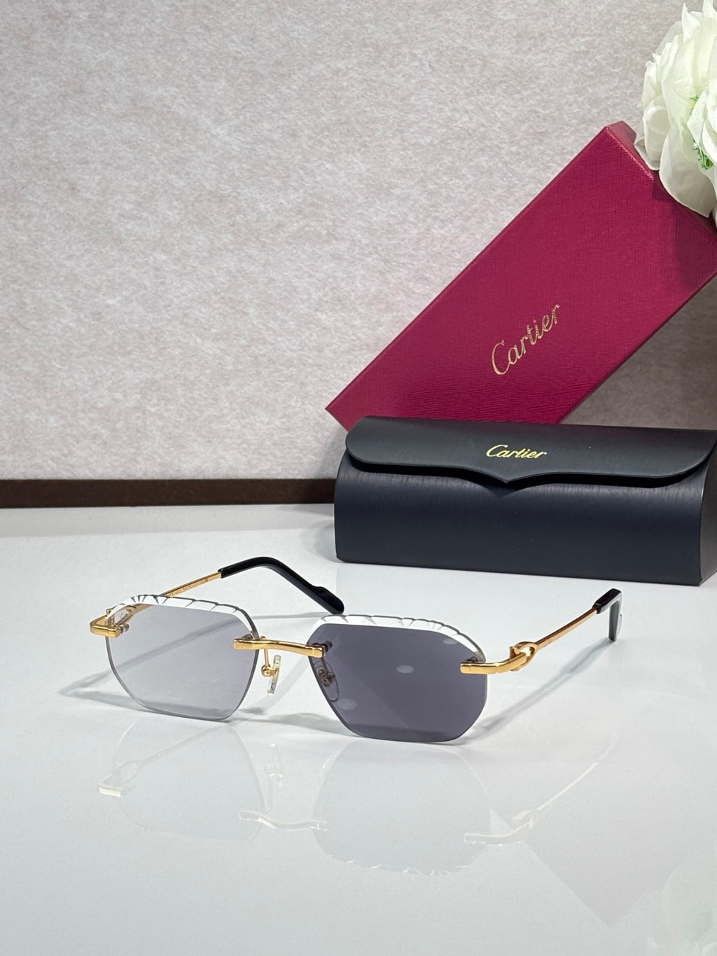 Cartier sunglasses with dark gray lenses and black frame, gold accents