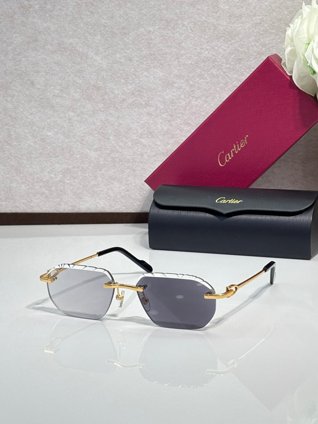 Cartier sunglasses with dark gray lenses and black frame, gold accents